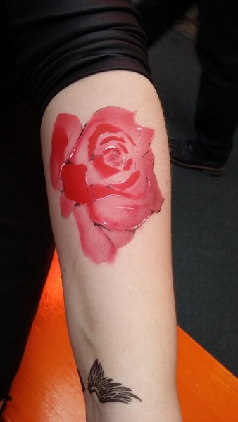 rote Rose auf dem Unterarm geairbrusht - die Blattabgrenzungen mit schwarz und weiß scharfkanting nach gezeichnet
