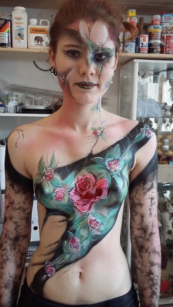 Bodypainting- es wird der Oberkörper mit bunten Blumen bemalt. in rot und lilatönen die Blätter sind grün. Es war ein gelungener Kurs