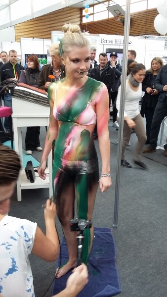 Bodypainting in grüntönen und pink. Der Körper wird koplett mit grün, rosa und pink Farbe bepinselt. Dann werden die Logos von Google, Firmenlogo Heiduk und Faceboot auf den Körper geairbrusht.