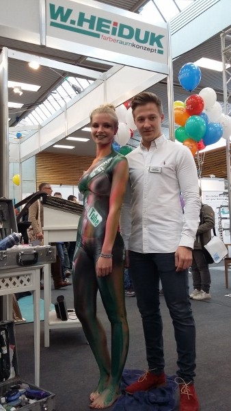 Bodypainting in grüntönen und pink. Der Körper wird koplett mit grün, rosa und pink Farbe bepinselt. Dann werden die Logos von Google, Firmenlogo Heiduk und Faceboot auf den Körper geairbrusht. 