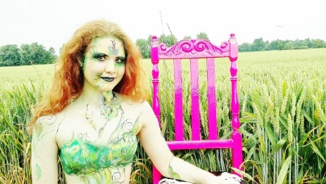 Bodypainting mit dem Thema Elfe. Es wurden aus Drat Flügel geformt. Diese wurden mit Frischhaltefolie bespannt. Der Körper wurde mit Blumen und Blätter angemalt und geairbrusht. Die Farben waren hauptsächlich in Grün gehalten. Das Gesicht wurde in grün und gold gehalten - es sah richtig schön zu dem roten Haaren. Als Deko stand ein pinkfarbener Stuhl im Kornfeld