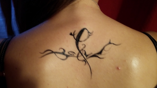 Bodypainting auf den Rücken mit schwarzer Farbe wurde auf einen Rücken ein Muster gemalt