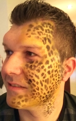 die linke Gesichtshälfte wurde mit gold und schwarz ein Leopardenmuster angebrusht