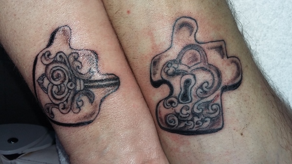 Das Tattoo gehört zusammen. Es sind zwei Pusselteile in denen einmal ein Schlüssel  ist und im anderen das Schlüsselschloss das Tattoo ist in schwarz und auf den innenseiten der Armgelenke zweier Leute