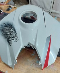 ein weisser Tank ist mit einem Löwenkopf in schwarz-weiss geairbrusht ein roter Pfeil ist als desing geairbrusht