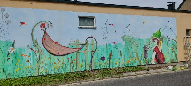 Airbrush und Malerei an einer Kindergartenaussenwand. in grün gehalten mit einem Haus als Pilz  sowie eine Hängematte gealten von zwei Blumenstielen in grün mit roten Blumen