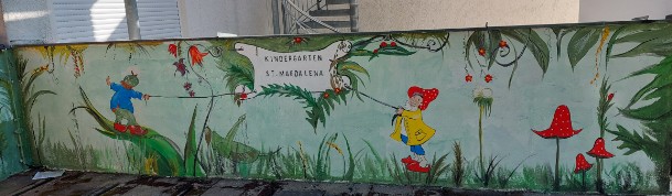 Airbrush und Malerei an einer Kindergartenaussenwand. in grün gehalten mit einem Haus als Pilz  sowie eine Hängematte gealten von zwei Blumenstielen in grün mit roten Blumen