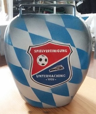 eine Kuhglocke wurde für Fußballspiele geairbrusht in bayrisch karo Blauweiß. darauf in rot-weiß-blau ein Wappen
