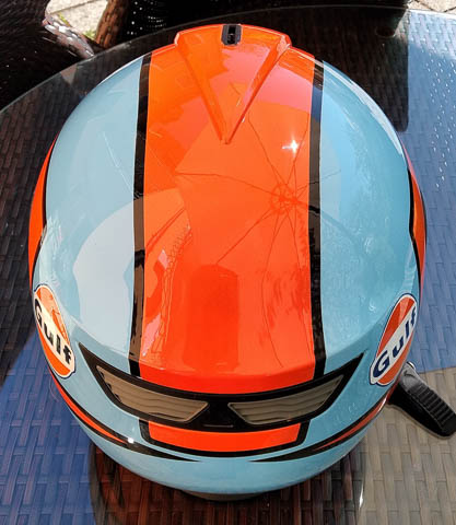 ein Helm wurde in hellblau und orang geairbrusht der Schriftzug mit dem Namen Gulf ist in dunkelblau geschrieben