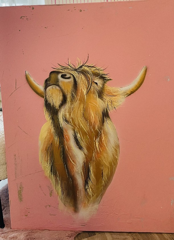 es wurde auf einen rosahintergrund eine Kuh in brauntönen und  goldfarbe geairbrusht und gemalt