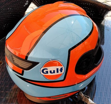 ein Helm wurde in hellblau und orang geairbrusht der Schriftzug mit dem Namen Gulf ist in dunkelblau geschrieben