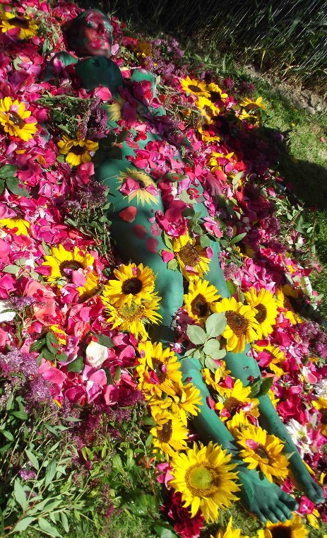 in dieser Blumenwiese liegt eine Frau sie ist bemalt mit Blumen und Blätter