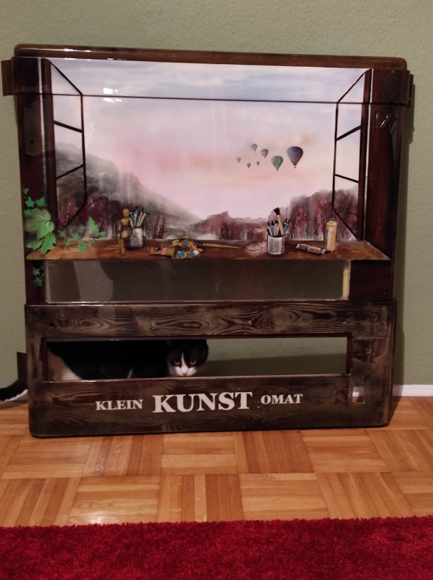 es wurde ein Zigarrettenautomat umfunktioniert in ein Automat von dem man selbstgemachte Geschenkartikel ziehen oder kauten kann. Er wurde in einem braunton geairbrusht und gemalt. im Himmel befinden sich Ballone