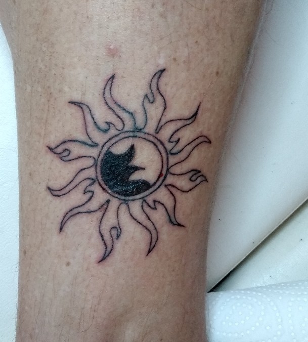 Tattoo in schwarz in Form einer Sonne