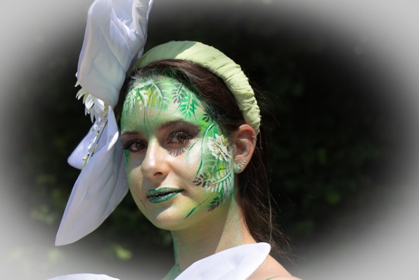 das Gesicht eines jungen Mädchens wurde von mir mit Blumen in bunten Farben geairbrusht und bemalt. Es wurden die Farben rot, grün, weiß schwarz und Glitter verwendet.