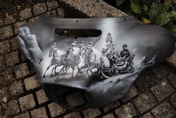 in schwarz-weiss geairbrusht und gemalt. auf ein Motorradteil wurde der König Ludwig auf ein schwarzes Motorradtweil auf gebracht.