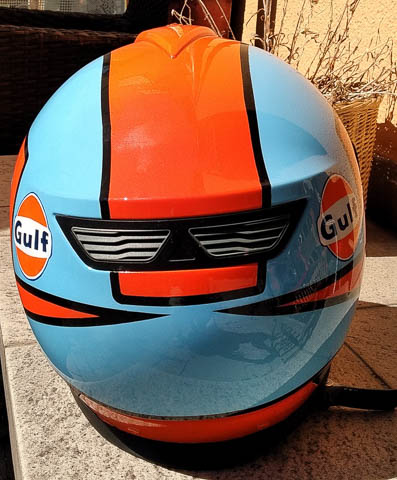 ein Helm wurde in hellblau und orang geairbrusht der Schriftzug mit dem Namen Gulf ist in dunkelblau geschrieben